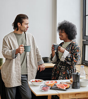 Couple enjoying breakfast together at home with coffee and fruit.
