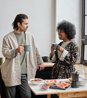 Couple enjoying breakfast together at home with coffee and fruit.